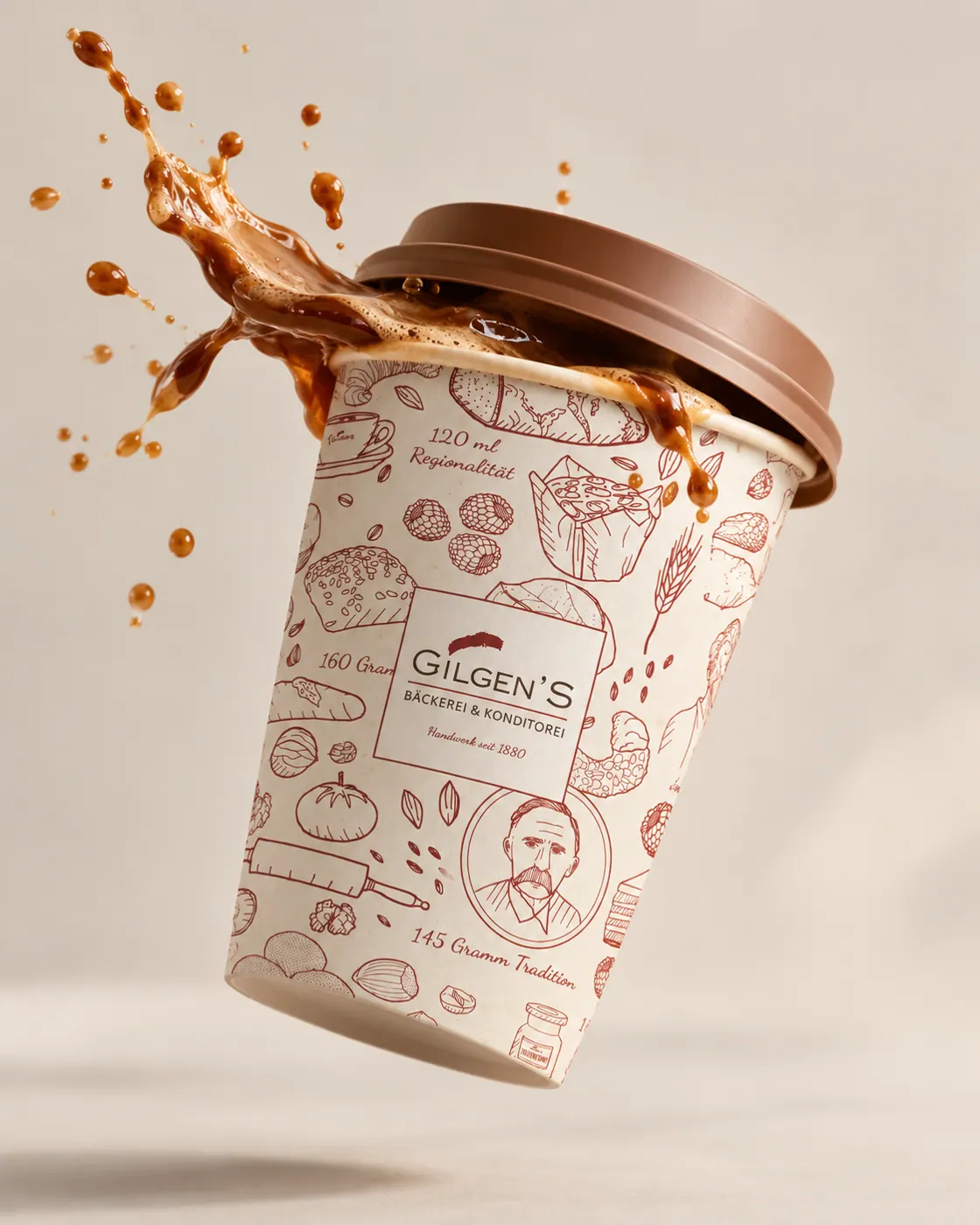 Gilgens Coffee-to-go-Becher mit illustriertem Bäckerei-Muster und Kaffeespritzern