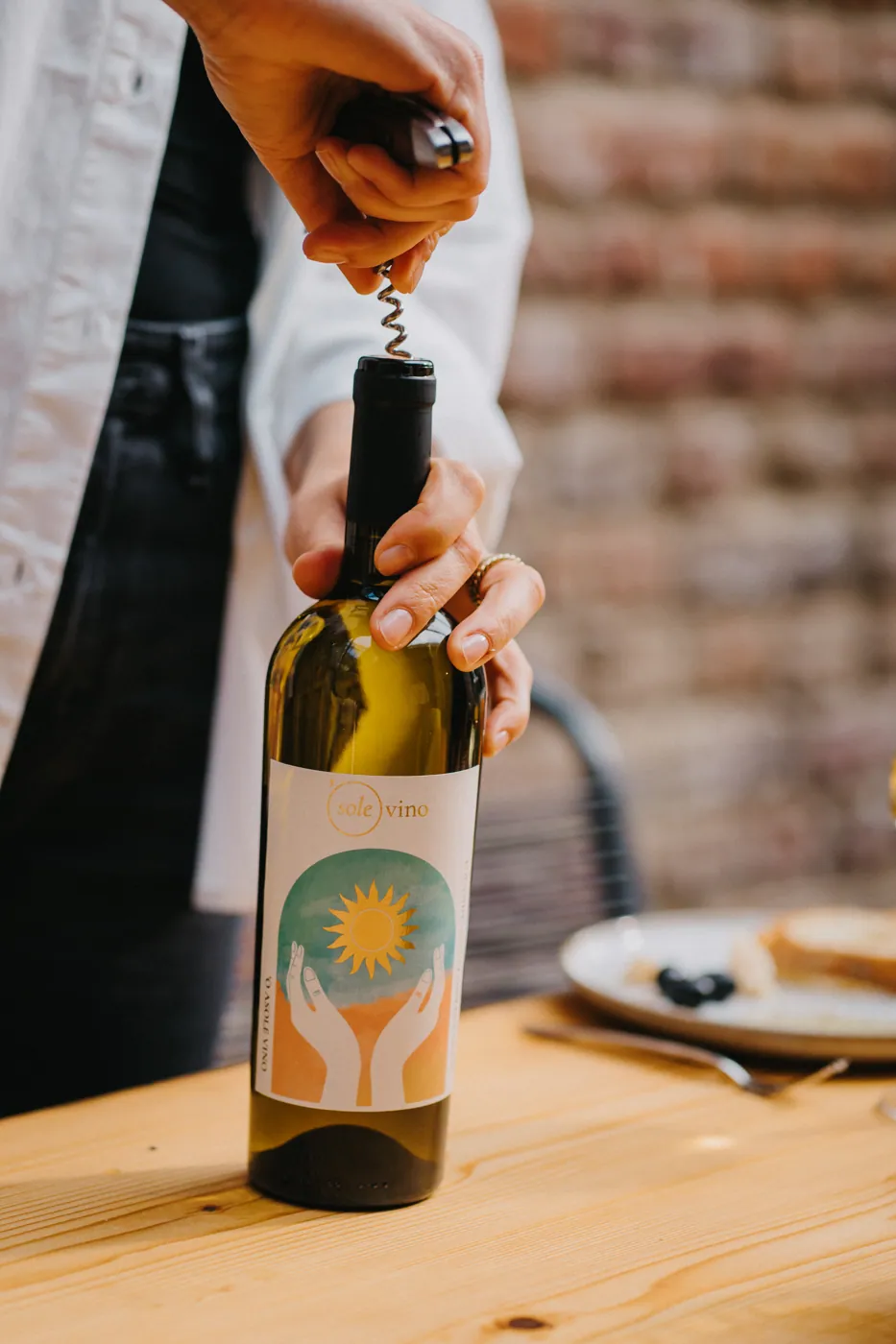 Hand entkorkt eine Flasche Sole Vino